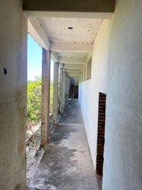 a hallway leading to a building with concrete walls