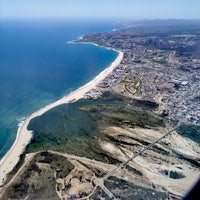 an aerial view of a beach and ocean from an airplane