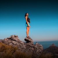 a woman standing on top of a rock