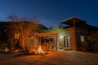 a house with a fire pit in the desert at night