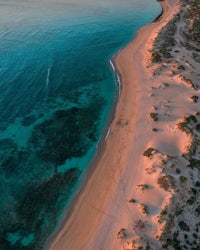 an aerial view of a beach at sunset