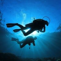 two scuba divers under the sun