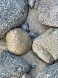 a close up of rocks and sand on the beach