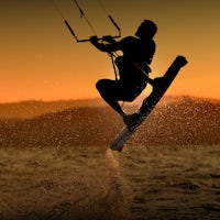 a man is kitesurfing in the water at sunset