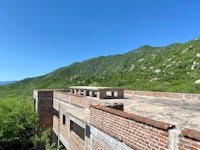 an abandoned building with a view of mountains