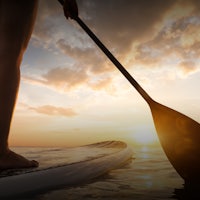 a person standing on a paddle board