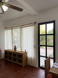 a living room with a ceiling fan and sliding glass doors